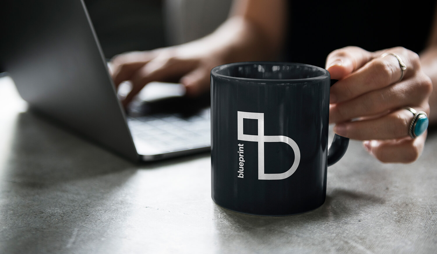 Blueprint branded coffee mug and laptop